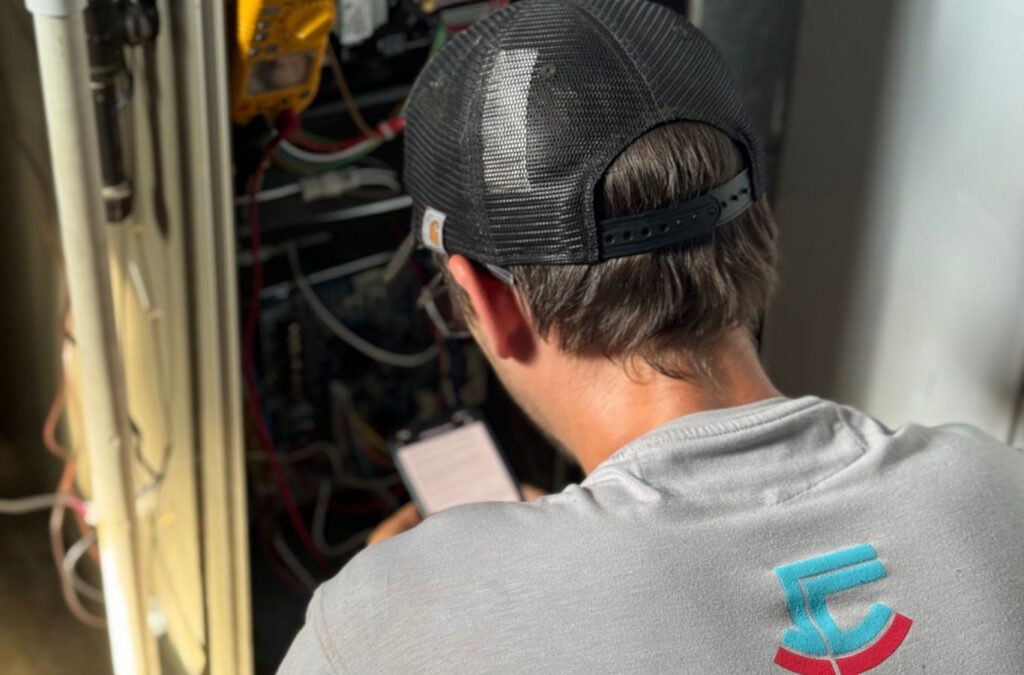 Franklin Heating Cooling and Refrigeration technician inspecting an indoor heating system for HVAC contractor services in Delaware County, OH. HVAC contractor near me.