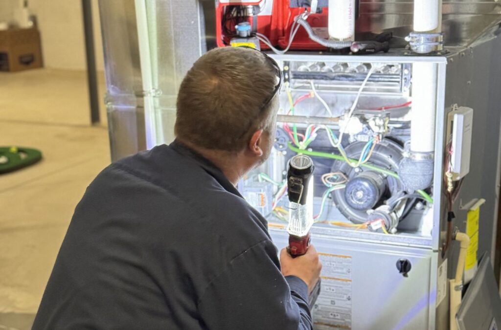 Franklin Heating Cooling and Refrigeration technician inspecting furnace components for HVAC contractor services in Fairfield County, OH. HVAC contractor near me.