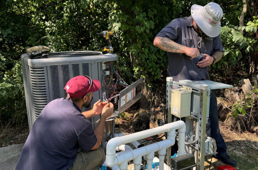 Franklin Heating Cooling and Refrigeration technicians inspecting an outdoor AC unit for HVAC contractor services in Franklin County, OH. HVAC contractor near me.