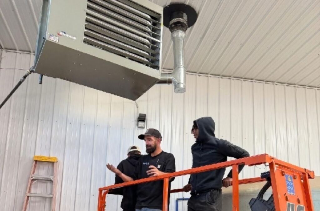 Franklin Heating Cooling and Refrigeration technicians servicing a suspended heater from a lift for HVAC contractor services in Sunbury, OH. HVAC contractor near me.