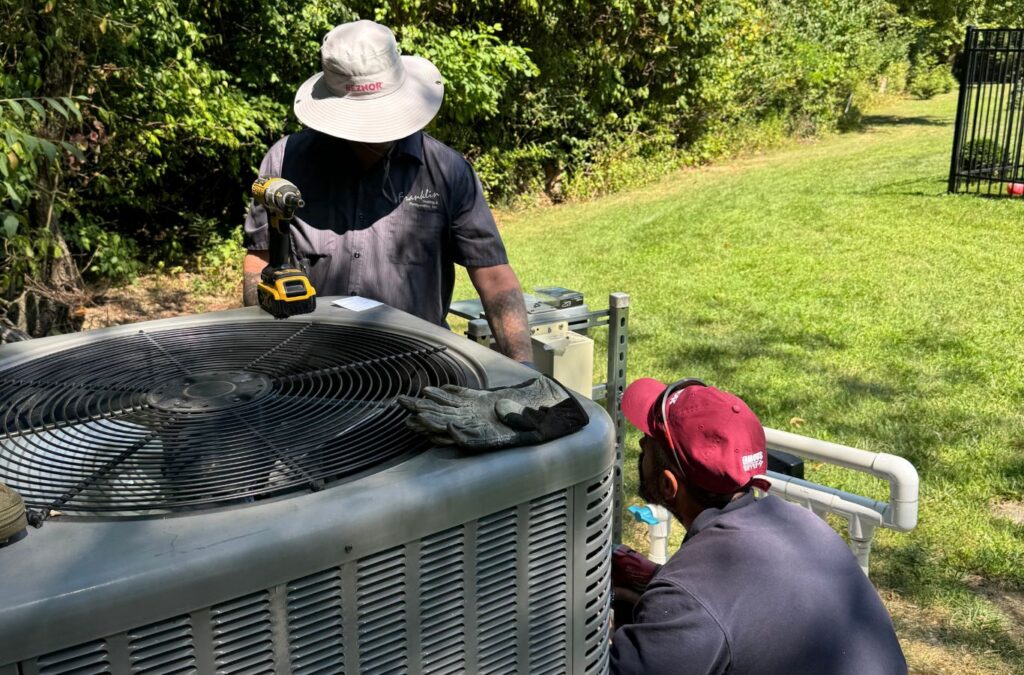 Technicians servicing an outdoor air-conditioning unit — Franklin Heating Cooling and Refrigeration AC repair services in Delaware, OH. AC repair near me