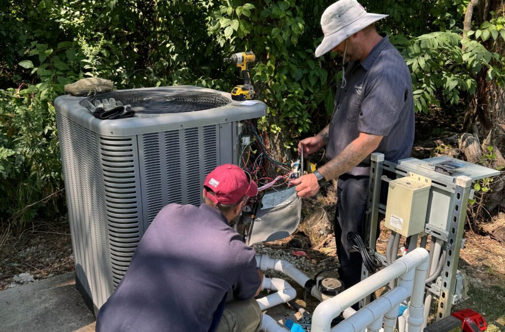Franklin Heating Cooling and Refrigeration technicians checking outdoor cooling equipment for HVAC contractor services in Hilliard, OH. HVAC contractor near me.