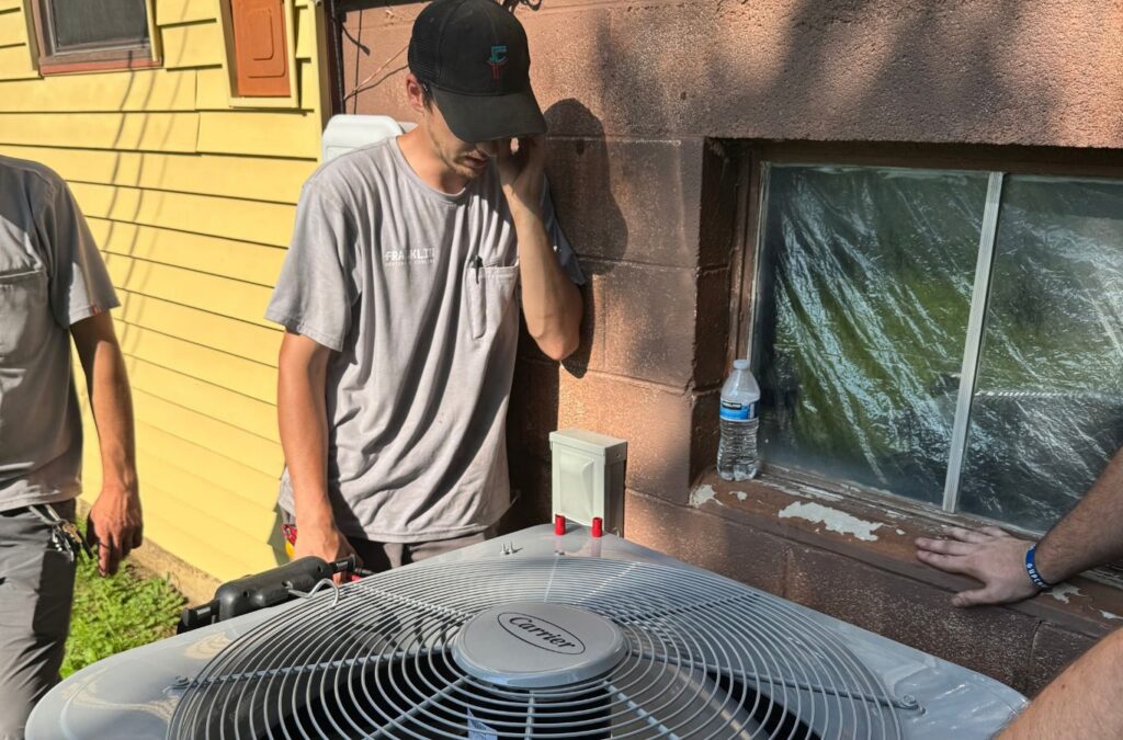 Technician beside an outdoor air-conditioning unit — Franklin Heating Cooling and Refrigeration AC repair services in Upper Arlington, OH. AC repair near me