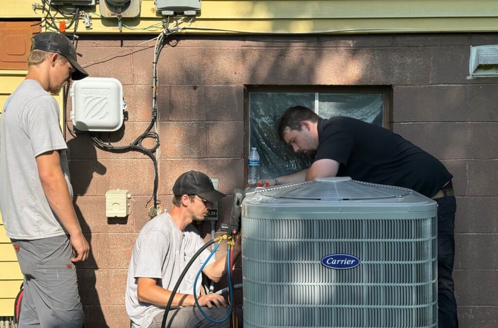 Franklin Heating Cooling and Refrigeration crew servicing a residential air-conditioning unit for HVAC contractor services in Delaware, OH. HVAC contractor near me.
